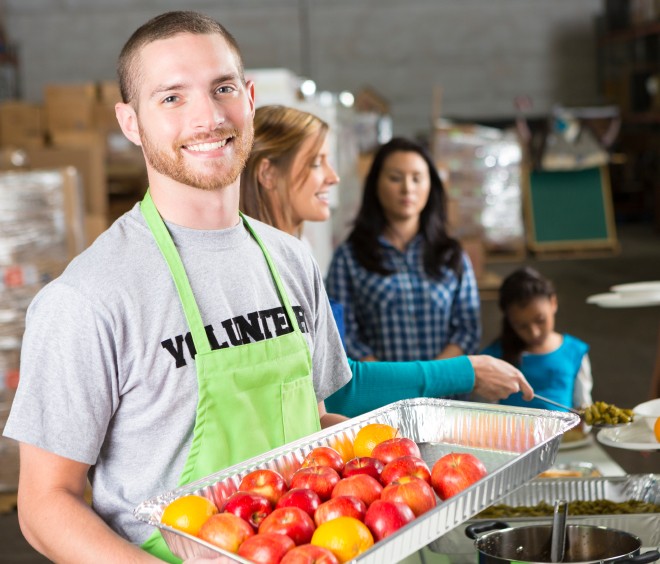 Smiling volunteers serving food